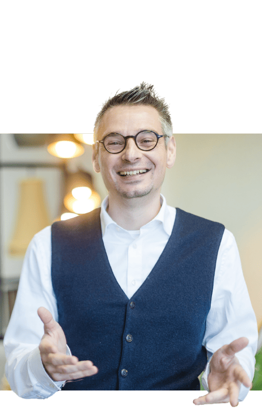 Patrick Schnelle begrüßt Dich mit offener Handbewegung
